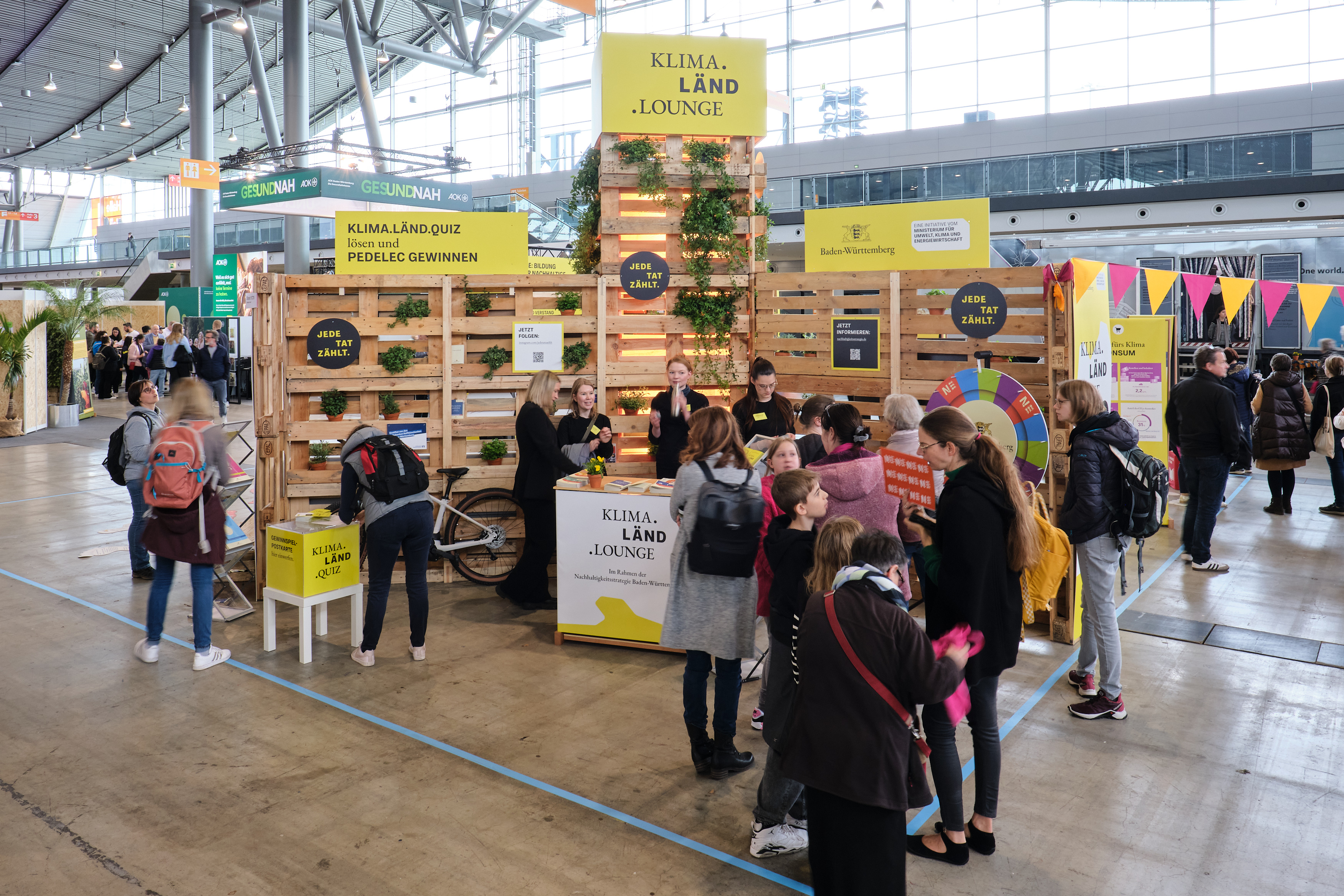 Menschen am Stand der Klima-Länd-Lounge auf einer Messe