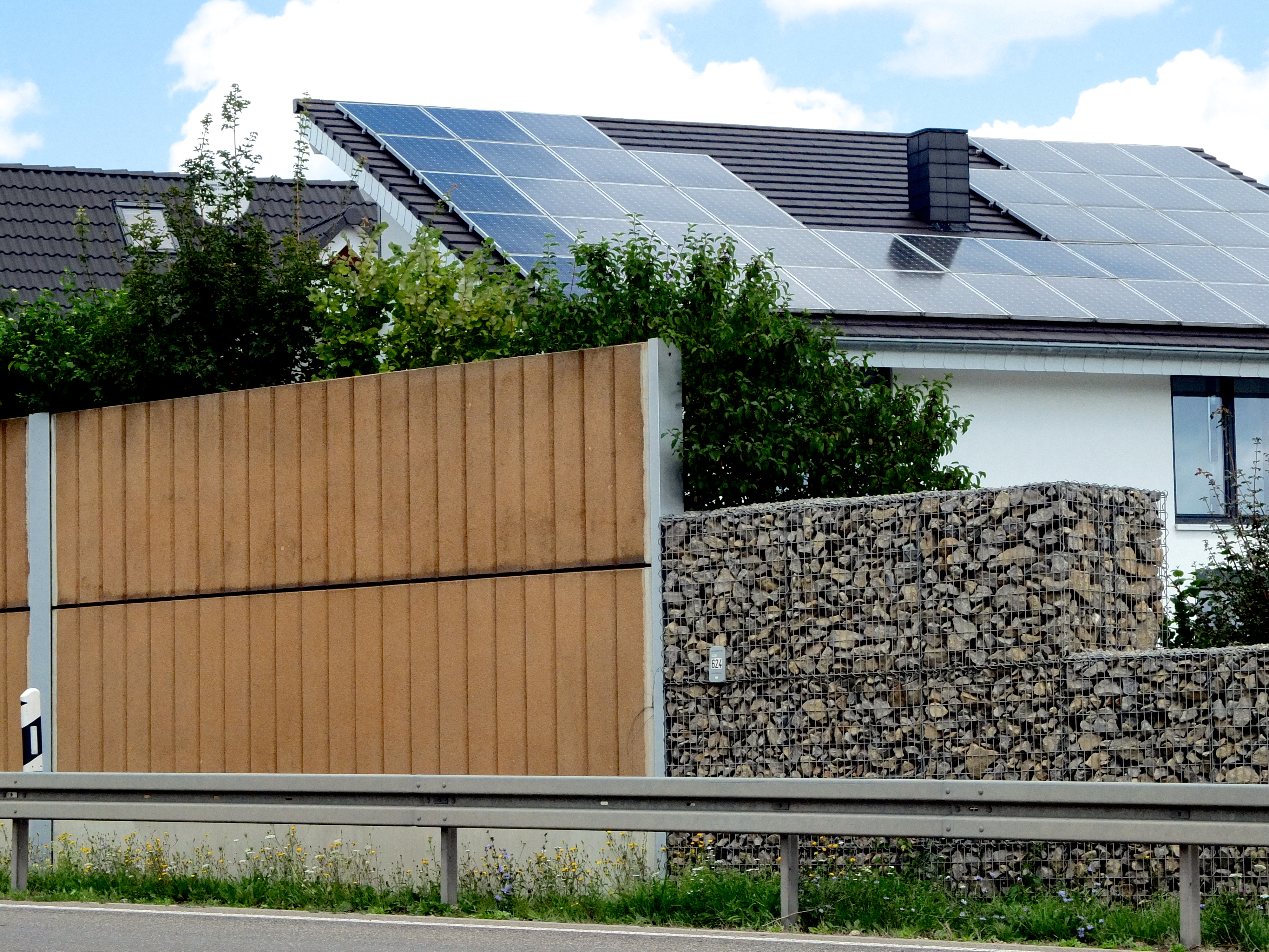 Lärmschutzwand entlang einer Straße zum Schutz eines Wohnhauses